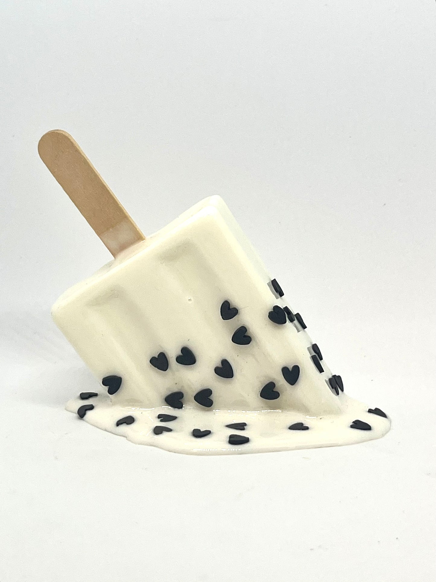 White melting popsicle resin sculpture with black heart sprinkles